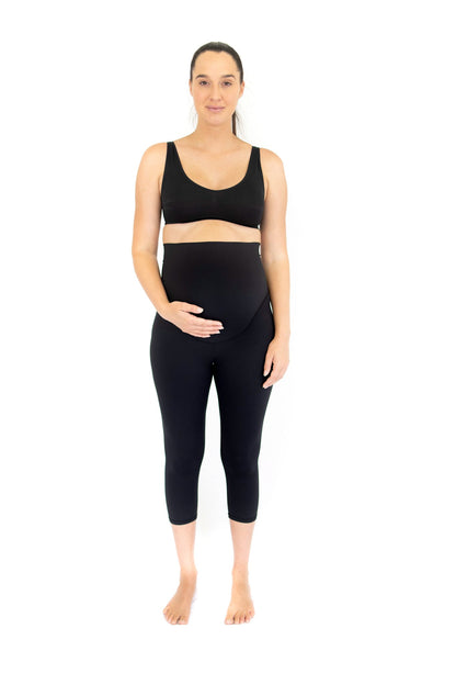 Woman in black athletic maternity leggings demonstrating completely specialised support