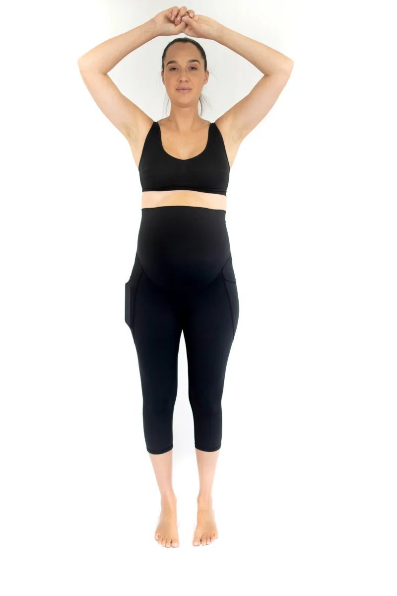 Woman in black workout attire celebrating comfort in completely specialised maternity leggings