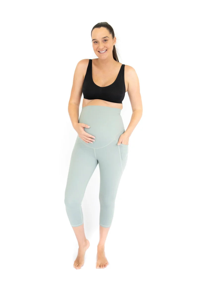 Woman in black sports bra and light blue maternity leggings from Spearmint collection