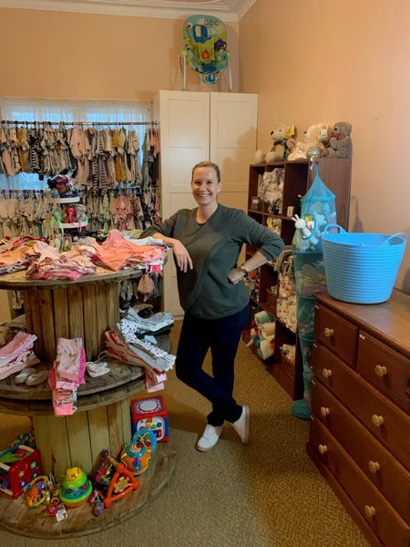 Wooden spool display rack with children’s clothing and toys for pregnancy assistance Bunbury.