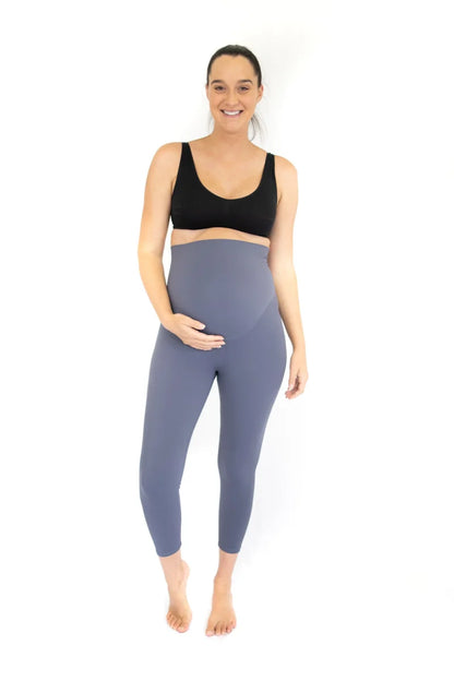 Pregnant woman in Emamaco maternity leggings in blue-gray and a black sports bra