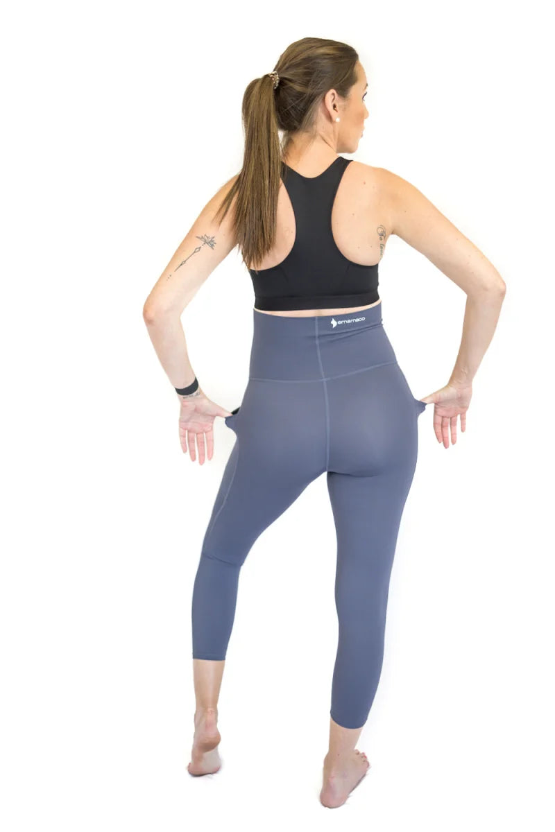 Woman in blue emamaco maternity leggings and black sports bra, viewed from behind