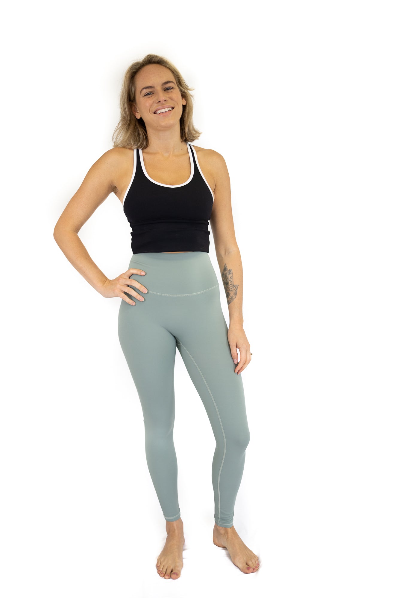 Woman in a black tank top and light blue leggings from 7/8 Shaper Move Leggings final sale