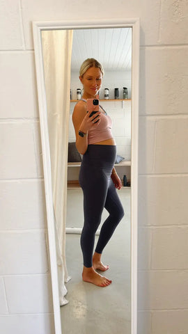 Mirror selfie of fitness attire for pregnancy workouts and post-birth rest options.