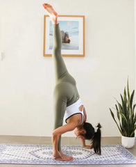 Handstand on a patterned yoga mat showcasing prenatal yoga in activewear during maternity.