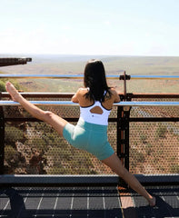 Dancer in activewear performing a split at scenic overlook, showcasing prenatal yoga benefits.