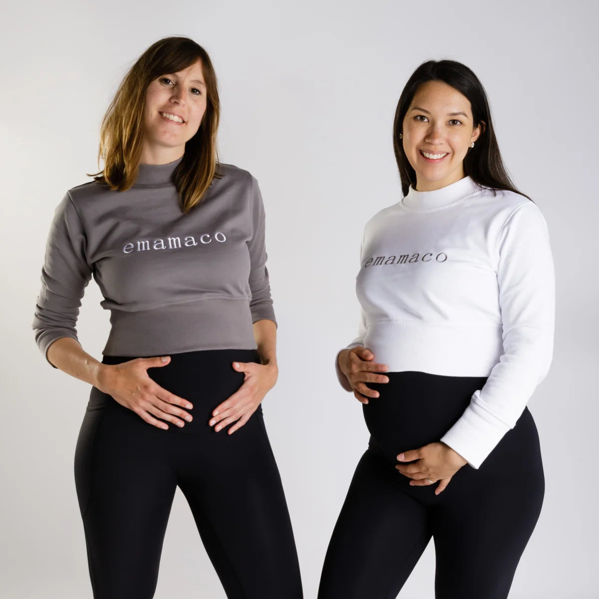 Two pregnant women in matching charcoal grey Mamaco sweatshirts and black leggings