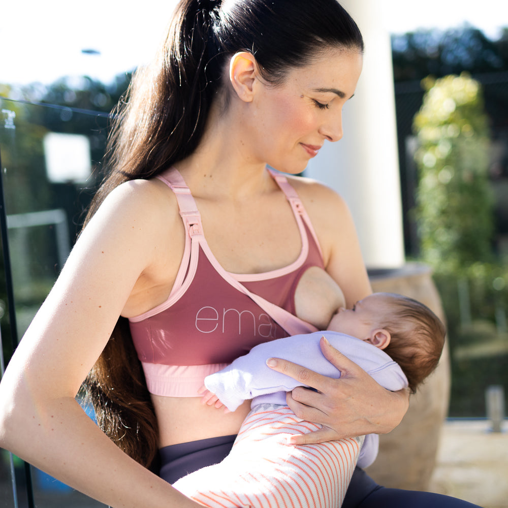 Woman breastfeeding infant in Elevate Nursing Sports Bra - Rose pink sports bra