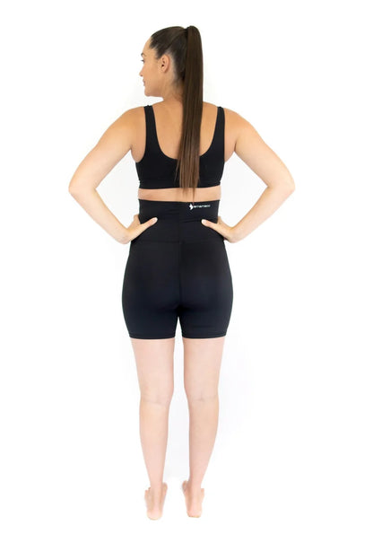 Woman in black workout attire showcasing Emama Maternity Bike Shorts for pregnant life