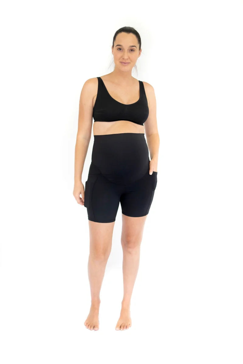 Woman in black Emama Maternity Bike Shorts with pockets for comfort and style