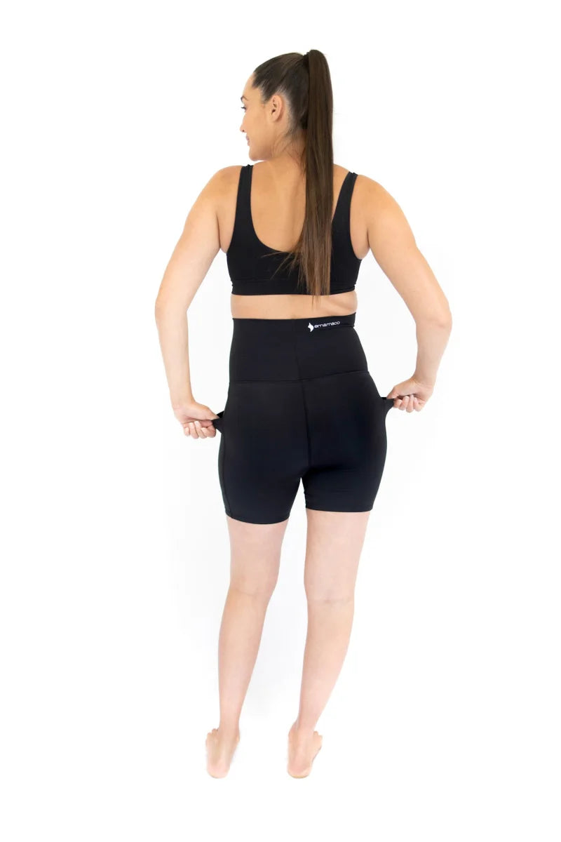 Woman in black Emama Maternity Bike Shorts with pockets, showing stylish back view