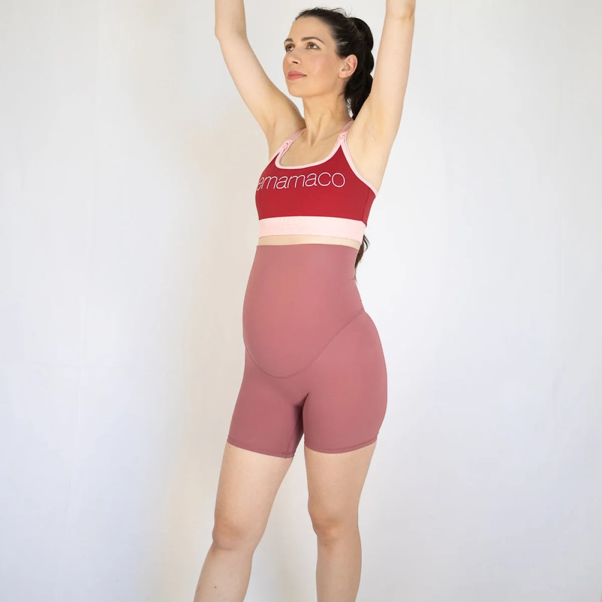 Woman in red and pink Emama Maternity Bike Shorts with pockets, showcasing comfort and style