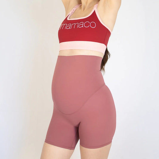 Woman wearing emama Maternity Bike Shorts in the newest colour rose with red sports bra