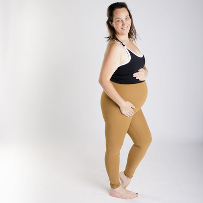 Pregnant woman in black top and tan Emama Maternity Leggings on final sale