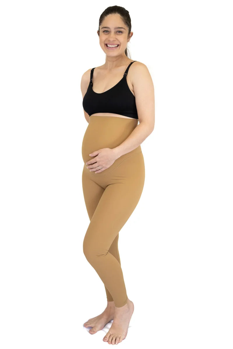 Pregnant woman in black top with Emama Maternity Leggings in caramel during final sale