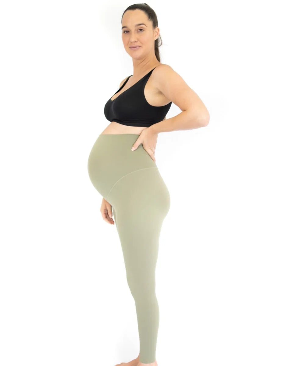 Pregnant woman in Emama Maternity Leggings, black sports bra and light green outfit