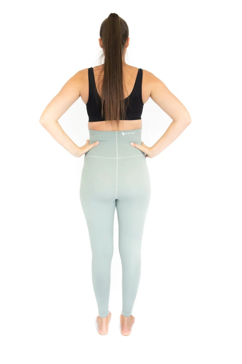 Woman in Emama Maternity Leggings, high-waisted blue with black sports bra, rear view