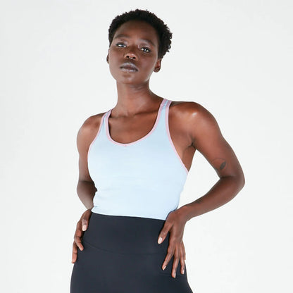 Woman in a white long line crop top and dark bottoms, showcasing maximum support