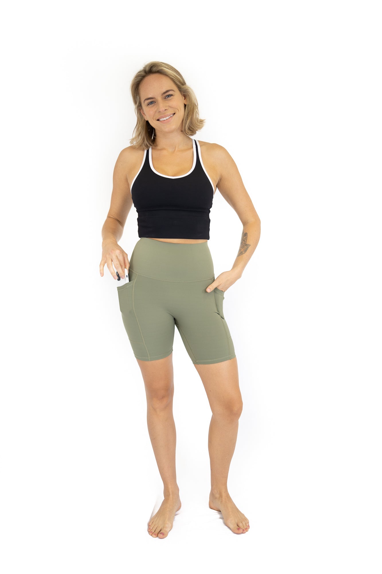 Woman in black crop top and olive green bike shorts for Final Sale, limited sizes remaining