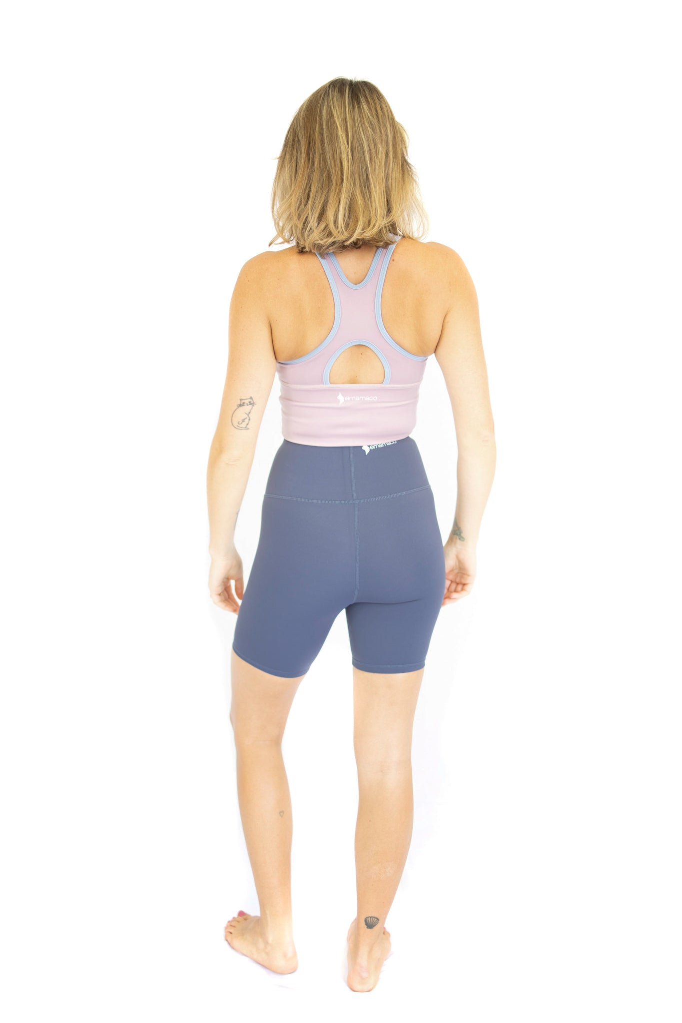 Woman in lavender sports bra and blue shorts showcasing Shaper Move Shorts on final sale