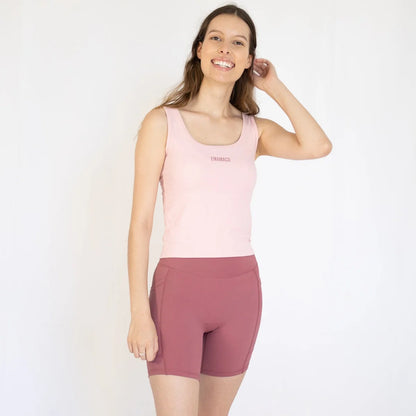 Woman in pink tank top and mauve cycling shorts, perfect for Emamaco Everyday yoga studio