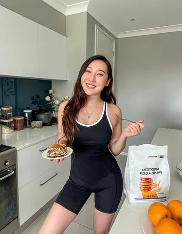 Person in black athletic wear enjoying a healthy meal in a stylish kitchen.