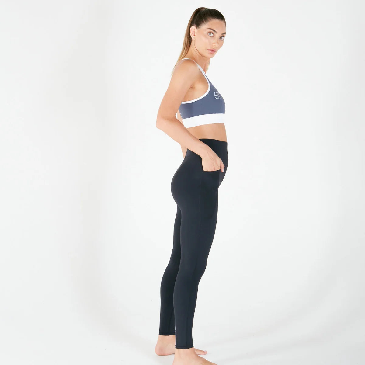 Woman in side profile wearing Vibe Leggings with regular fit waistband in Black